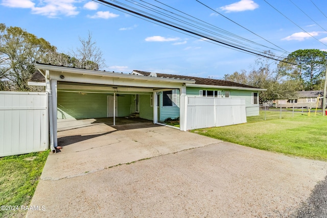 garage featuring a lawn and a carport