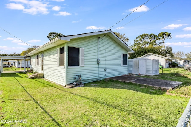 rear view of house with a storage unit and a yard