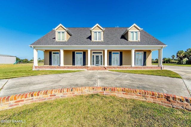 new england style home featuring covered porch and a front yard