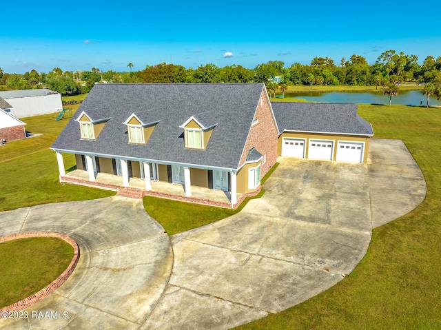 cape cod home featuring a water view, a front lawn, and a garage