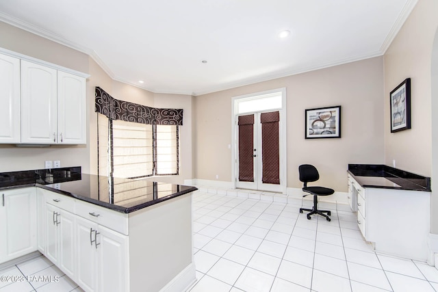 kitchen featuring ornamental molding, white cabinetry, light tile floors, and dark stone counters