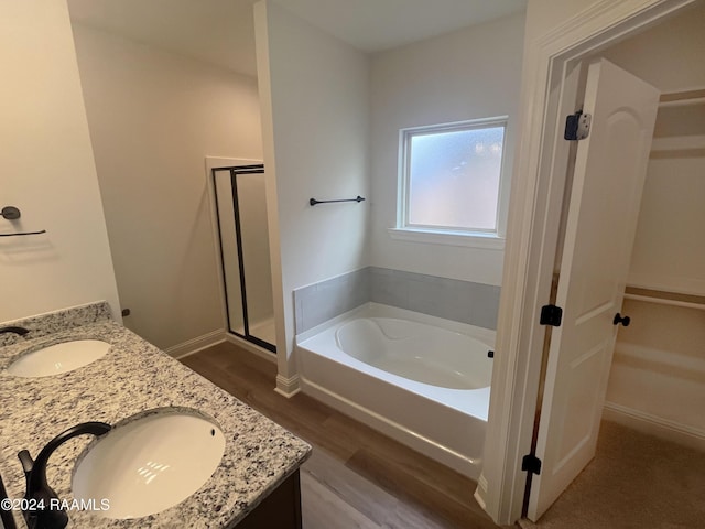 bathroom featuring independent shower and bath, vanity, and wood-type flooring