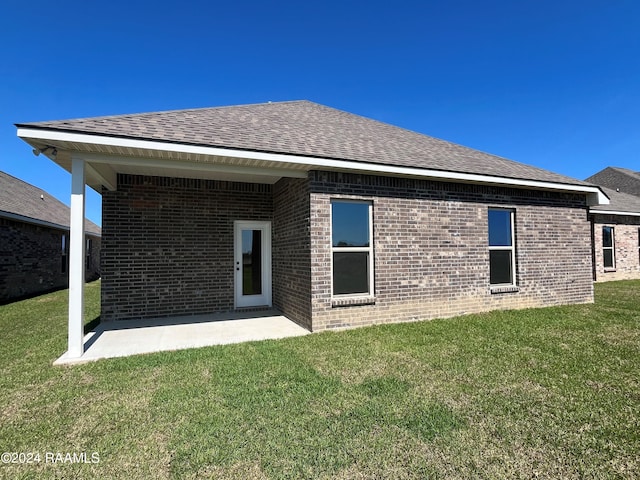 back of house with a yard and a patio