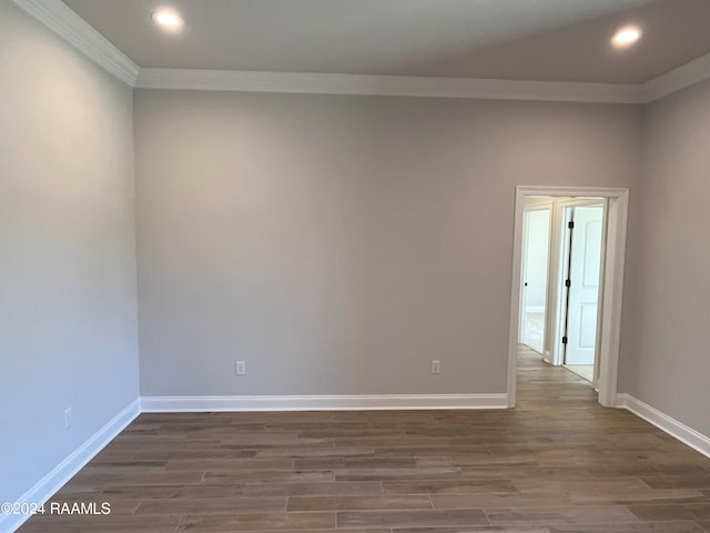 empty room with crown molding and dark hardwood / wood-style flooring