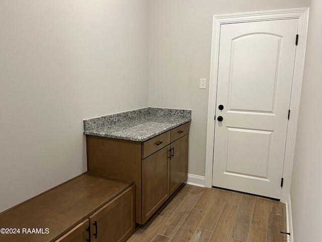 clothes washing area with light hardwood / wood-style floors