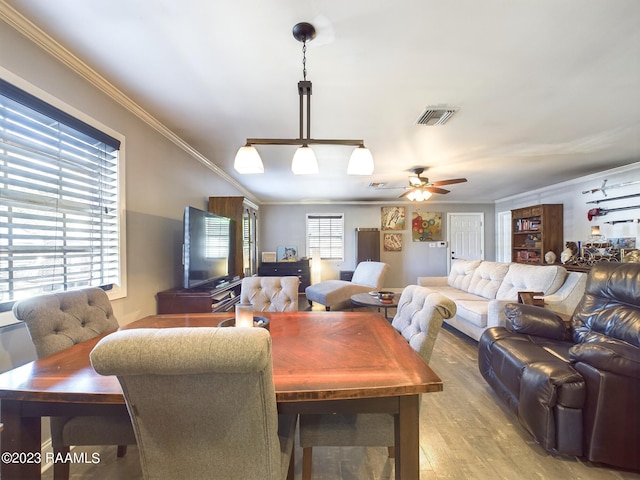 dining space with ceiling fan, crown molding, and light hardwood / wood-style flooring