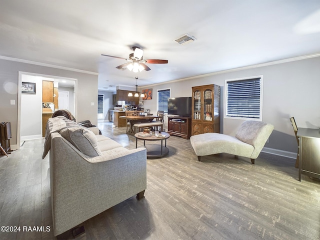 living room featuring hardwood / wood-style floors, ceiling fan, and crown molding