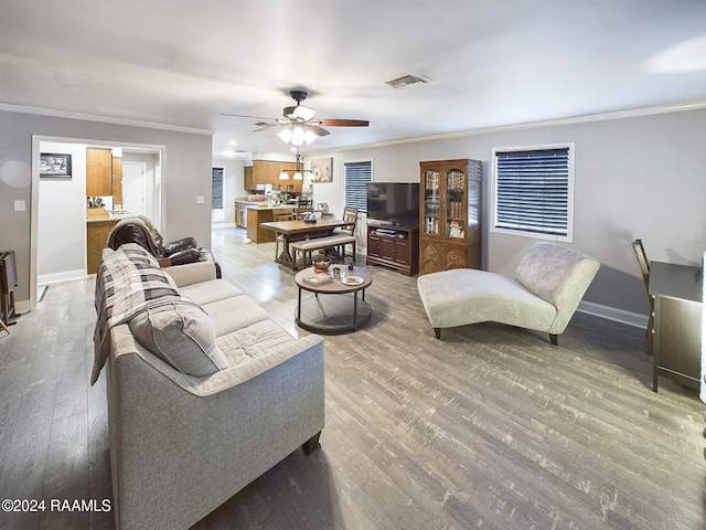 living room with hardwood / wood-style flooring, ceiling fan, and crown molding