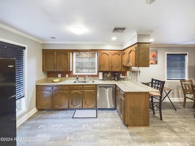 kitchen with sink, stainless steel dishwasher, kitchen peninsula, crown molding, and black refrigerator