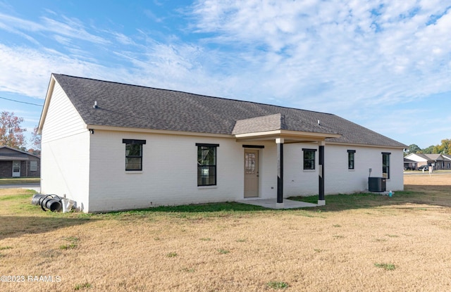 rear view of property with a lawn and central AC