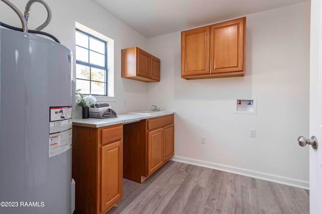 kitchen featuring electric water heater, light hardwood / wood-style flooring, and sink