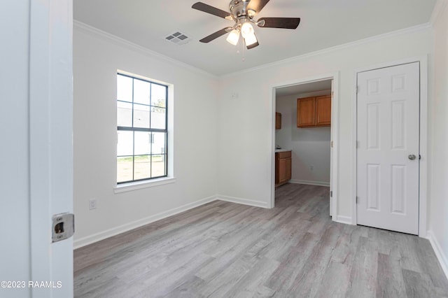 unfurnished bedroom featuring ceiling fan, crown molding, ensuite bath, and light hardwood / wood-style floors