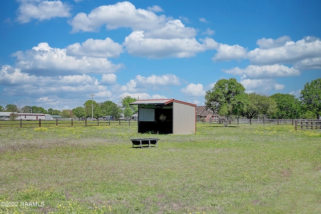 view of yard with a rural view and a storage unit