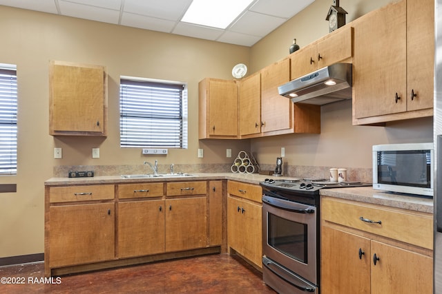 kitchen featuring sink, stainless steel appliances, plenty of natural light, and a drop ceiling