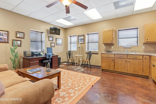 living room with ceiling fan, sink, and a paneled ceiling