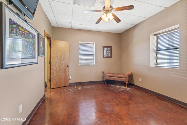 spare room featuring ceiling fan, a paneled ceiling, and plenty of natural light