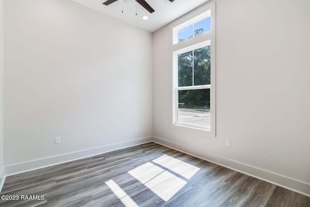 spare room featuring ceiling fan, plenty of natural light, and dark hardwood / wood-style flooring