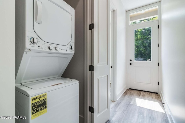 laundry area with light wood-type flooring and stacked washing maching and dryer