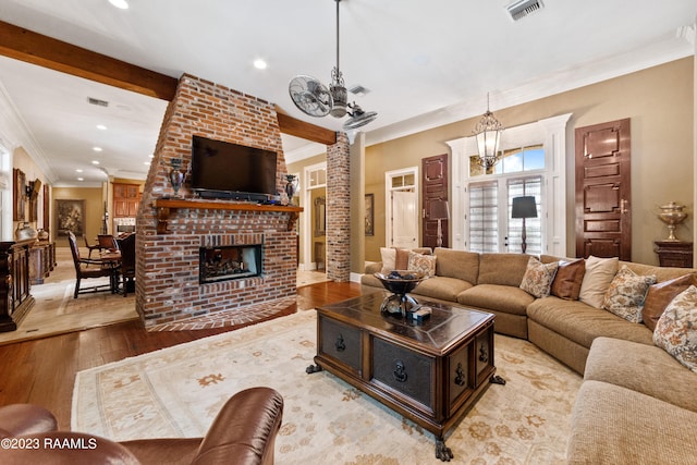 living room with french doors, a brick fireplace, ornamental molding, beam ceiling, and light hardwood / wood-style flooring