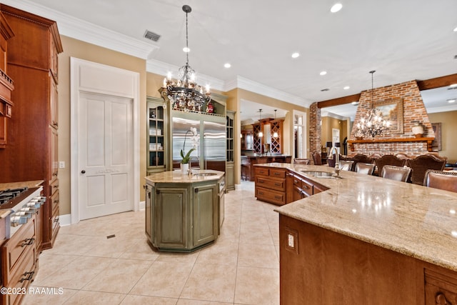 kitchen featuring a kitchen island with sink, sink, hanging light fixtures, ornamental molding, and a notable chandelier