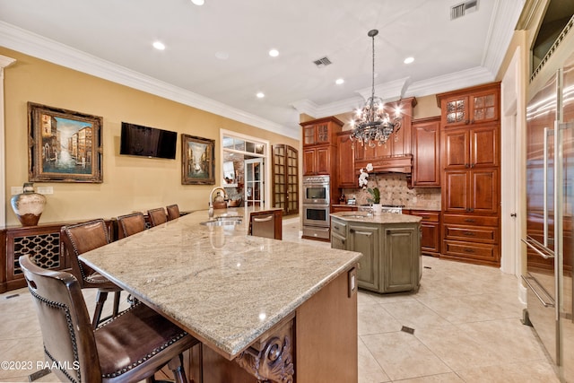 kitchen featuring tasteful backsplash, crown molding, a spacious island, sink, and decorative light fixtures