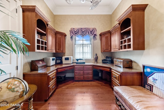 office with built in desk, dark hardwood / wood-style floors, and crown molding