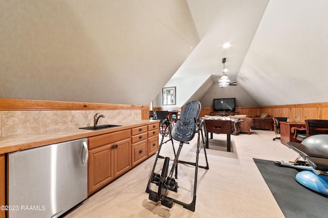 interior space featuring ceiling fan, sink, lofted ceiling, and wooden walls