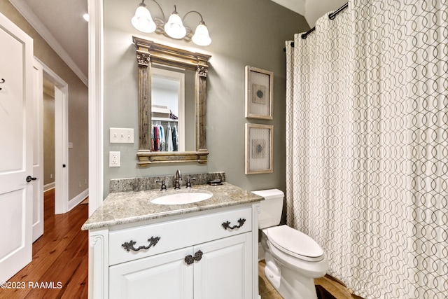 bathroom featuring walk in shower, toilet, hardwood / wood-style flooring, vanity, and ornamental molding