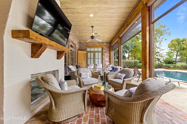 sunroom featuring ceiling fan, a swimming pool, and wooden ceiling