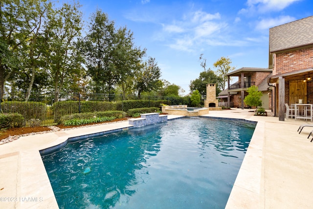 view of swimming pool featuring a patio area and an in ground hot tub