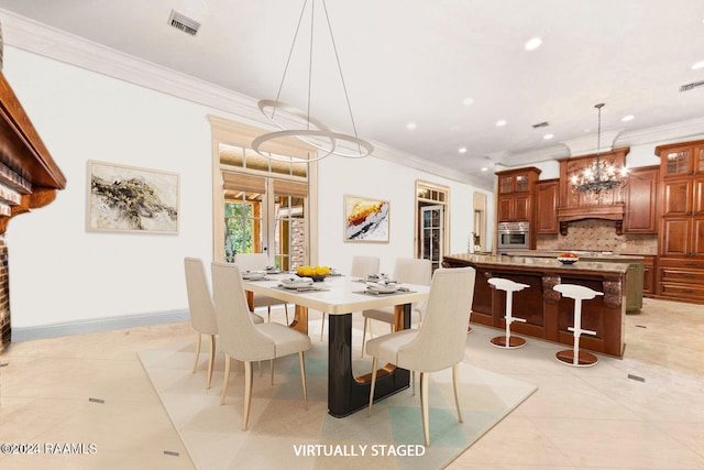 dining room with light tile patterned flooring, ornamental molding, and an inviting chandelier