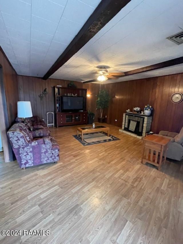 105 S 1st St, Gueydan, LA 70542 - living area featuring beamed ceiling, wooden walls, wood finished floors, and ceiling fan