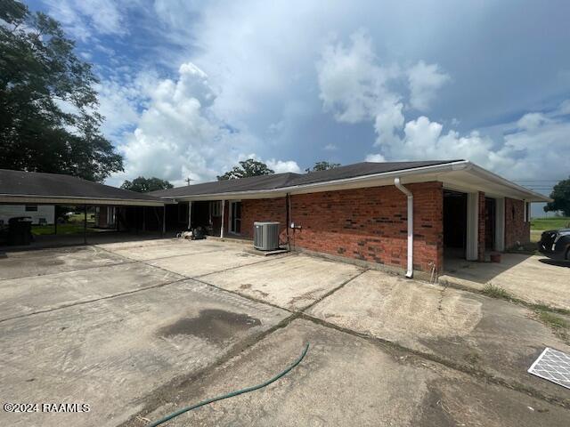 105 S 1st St, Gueydan, LA 70542 - view of home's exterior featuring brick siding, central air condition unit, and a carport