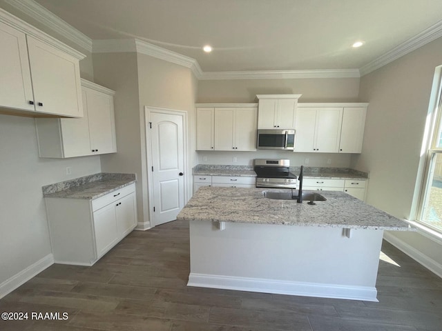 kitchen with sink, light stone counters, stove, white cabinets, and dark wood-type flooring