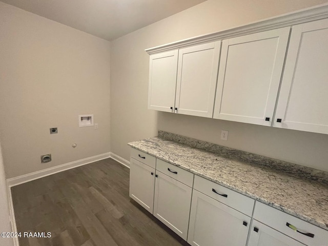 laundry room with washer hookup, electric dryer hookup, dark wood-type flooring, gas dryer hookup, and cabinets