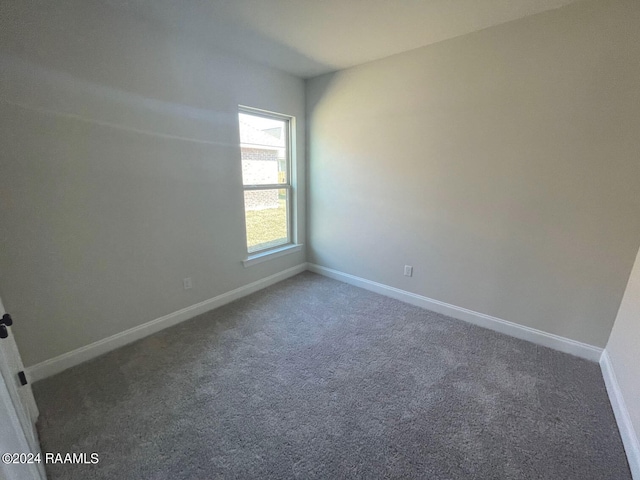 unfurnished room with dark colored carpet