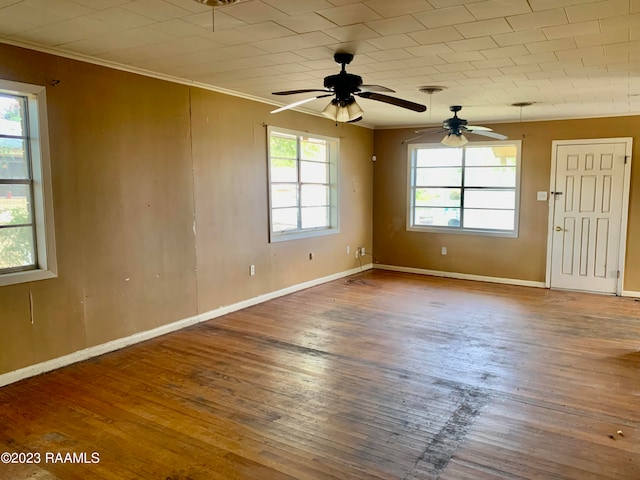 spare room with a healthy amount of sunlight, ceiling fan, ornamental molding, and dark wood-type flooring