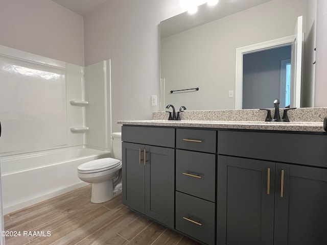 full bathroom with hardwood / wood-style floors, vanity, toilet, and shower / washtub combination