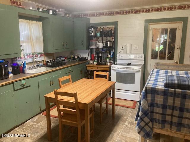 kitchen featuring sink, green cabinets, and white electric range oven