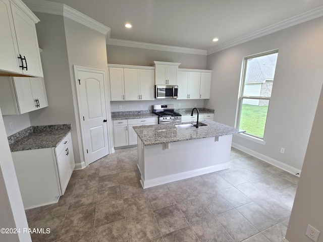 kitchen featuring white cabinets, a kitchen island with sink, sink, and appliances with stainless steel finishes