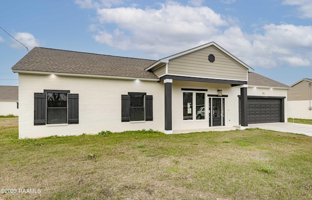 view of front of home with concrete driveway, a front lawn, a garage, and a shingled roof