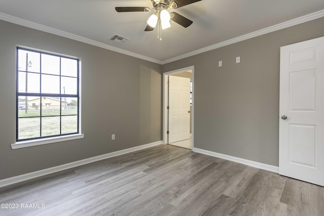 unfurnished room featuring visible vents, crown molding, baseboards, and wood finished floors