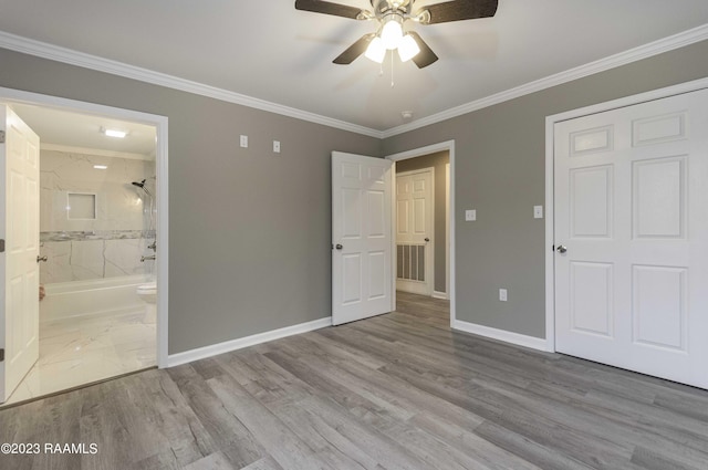 unfurnished bedroom featuring visible vents, ornamental molding, wood finished floors, connected bathroom, and baseboards