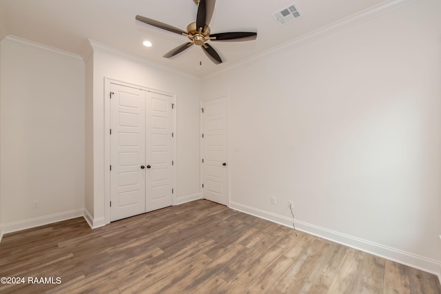 unfurnished bedroom featuring ornamental molding, ceiling fan, a closet, and hardwood / wood-style floors