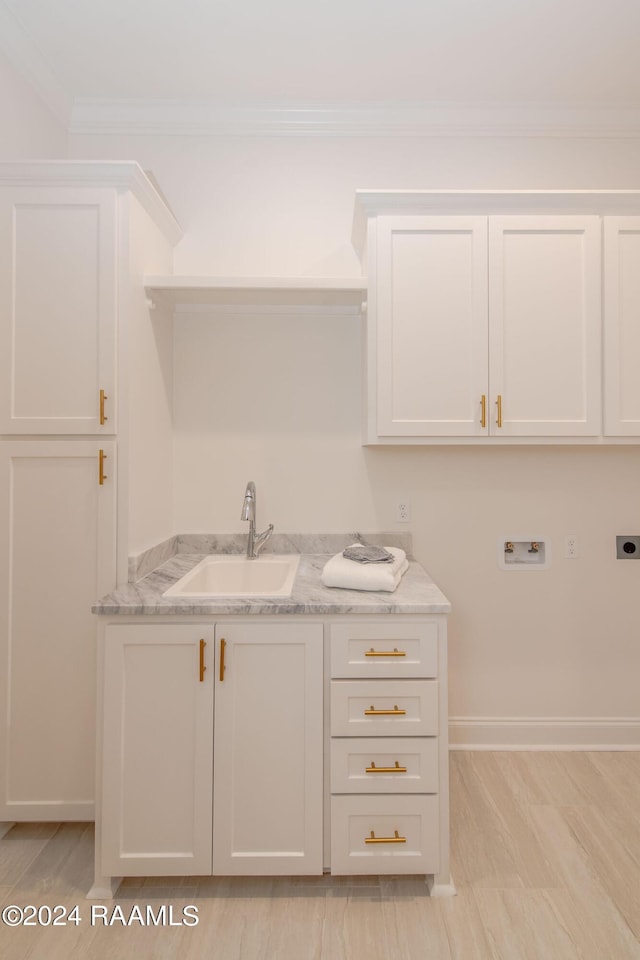 laundry area featuring washer hookup, hookup for an electric dryer, cabinets, crown molding, and sink