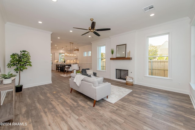 living room with ceiling fan, hardwood / wood-style flooring, and crown molding