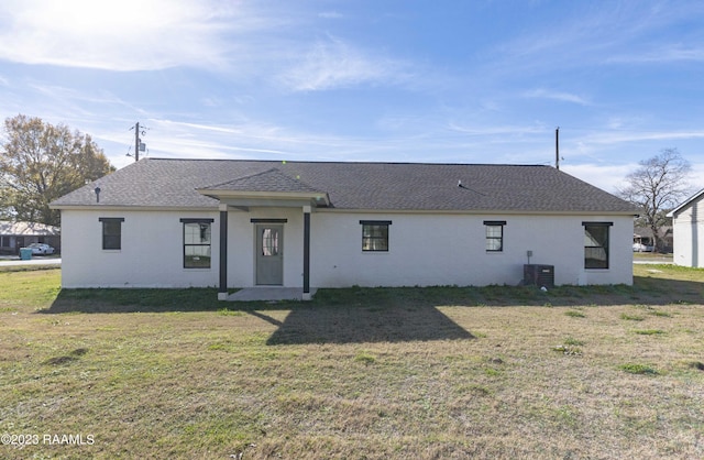 view of front of home with cooling unit and a front lawn