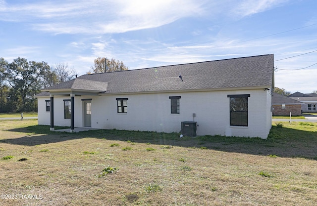 back of house featuring central AC and a yard