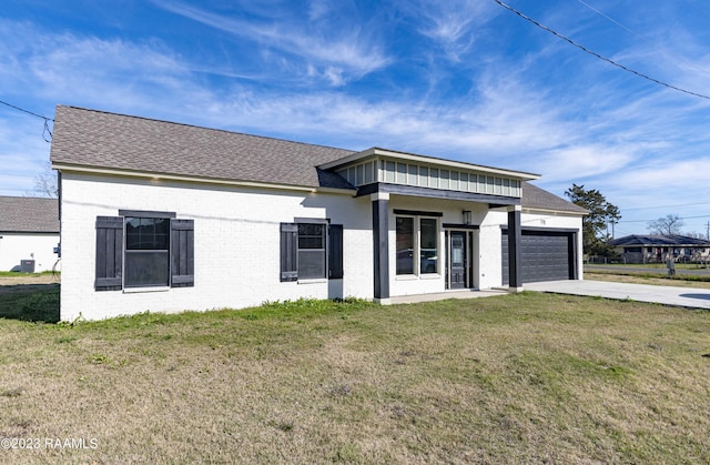 view of front of home with a garage and a front lawn