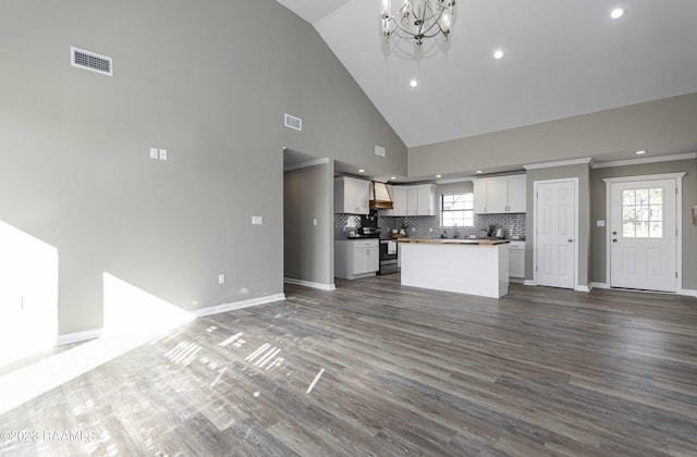 kitchen featuring a kitchen island, electric stove, an inviting chandelier, high vaulted ceiling, and white cabinetry